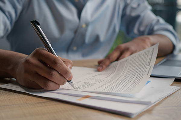 Image of an individual signing forms.