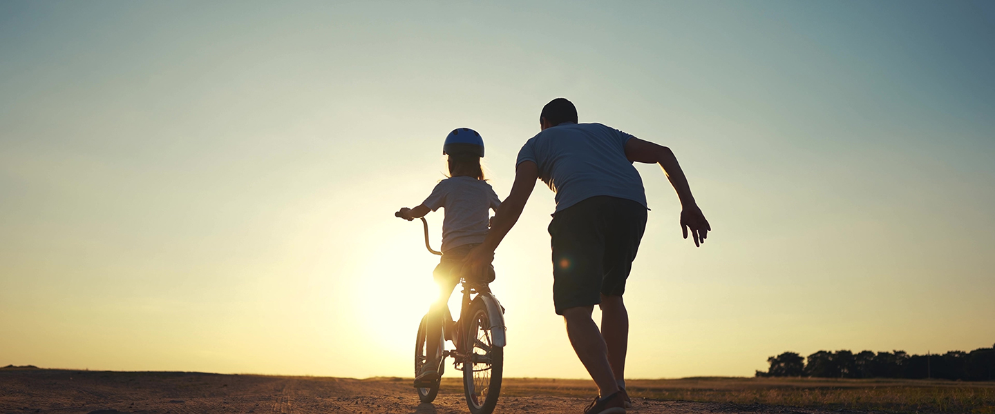 man helping girl ride bike